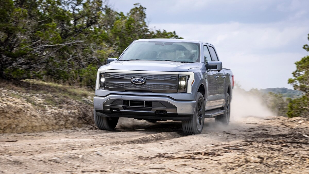 2024 Ford F-150 Lightning driving on sandy roads.